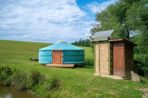a yurt and a shed next to a river at Jurta na Jitrech in Tábor