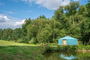 a blue tent in a field next to a river at Jurta na Jitrech in Tábor