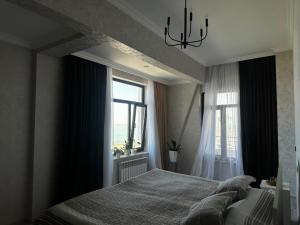 a bedroom with a large bed and a window at Caspian Boulevard Residence in Sumqayıt