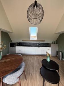a living room with a table and chairs and a chandelier at Lodge Wieringen in Hippolytushoef