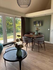a living room with a dining room table and chairs at Lodge Wieringen in Hippolytushoef