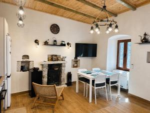 a dining room with a table and chairs and a fireplace at Ana & Angelo Stone House Vuno Himarë in Vuno