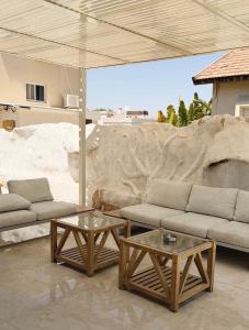a living room with two couches and two tables at Villa Sea House in Eilat