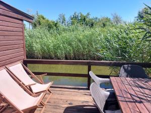 a wooden deck with chairs and a table and water at Kućica Dva Dječaka in Ulcinj +12 photos
