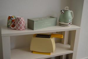 a shelf with a tea kettle and a box on it at Casa natura in Usini