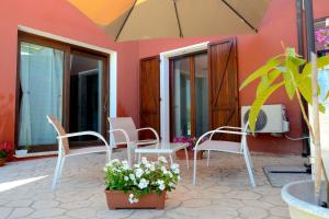 a patio with white chairs and an umbrella at Casa natura in Usini