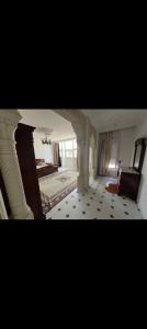 a large room with a bed and a chair at villa zgolli in Korba
