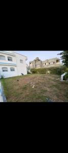 two pictures of two buildings and a yard at villa zgolli in Korba