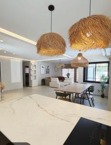 a living room with two pendant lights and a table at Villa Sea House in Eilat