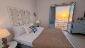 a bedroom with a bed with a view of the ocean at Elkaza Villas in Fira +47 photos
