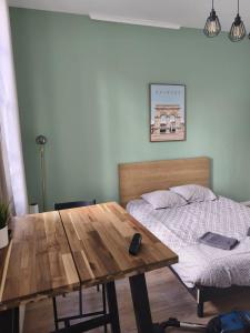a bedroom with a bed and a wooden table and a bed sidx sidx sidx at "Les Arches 2" City Center Studio in Saintes