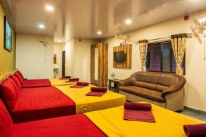 a hotel room with four beds and a couch at kumba stay in Kumbakonam