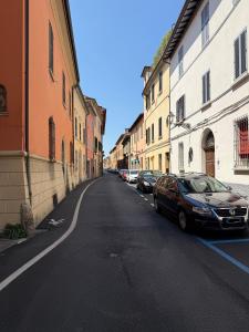 an empty street with cars parked on the sides of buildings at J&B Imola Home in Imola