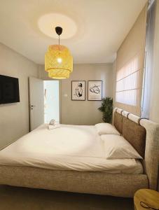 a bedroom with a large bed with a chandelier at Villa Sea House in Eilat +12 photos