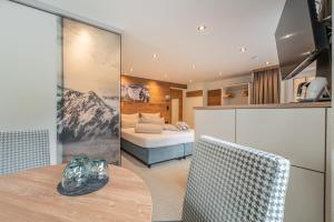 a kitchen with a table and a bed in a room at Garni Ötztal ROOMS & APARTS in Sölden