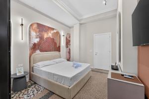 a bedroom with a bed with a painting on the wall at 2115 Boutique Hotel in Durrës