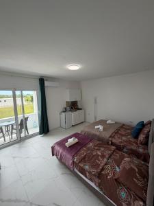 a bedroom with a large bed and a balcony at Apartments Gzim Peja in Ulcinj