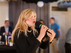 a woman holding a microphone in a room at ibis Compiegne in Compiègne