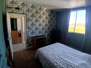 a bedroom with a bed and a window and a mirror at le bégare 