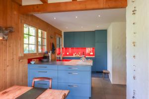 a kitchen with blue cabinets and a table at Les Jumelles in Rougemont