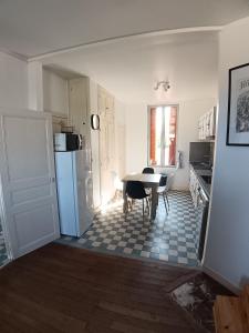 a kitchen with a table and a refrigerator in a room at le bégare 