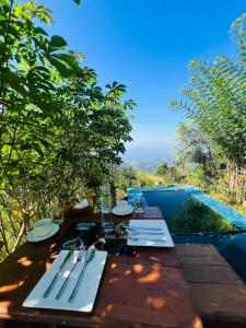 a table with utensils on it with a view of a pool at MOYE MOYE Ella in Ella