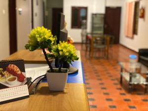 a table with a vase with yellow flowers on it at La Paradise Residency - TIE Hotels in Pondicherry