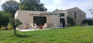 a house with chairs and a table in a yard at Gite des Egadillias climatisé in Marsanne +9 photos