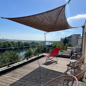 a patio with a red chair and chairs on a balcony at L'Atelier Sur Seine in Épinay-sur-Seine +58 photos