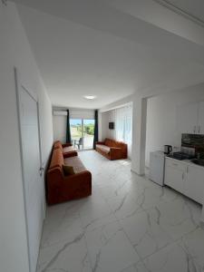 a living room with two couches and a kitchen at Apartments Gzim Peja in Ulcinj