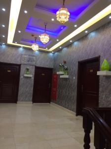 um átrio com duas portas e um tecto roxo em Jawharet Al Kheir Furnished Apartments em Salalah