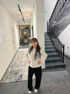 a woman standing in the middle of a staircase at Hostel in Talas
