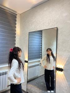 a woman standing in front of a mirror at Hostel in Talas