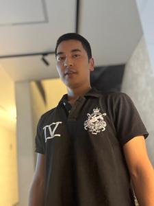 a man in a black shirt standing in a room at Hostel in Talas