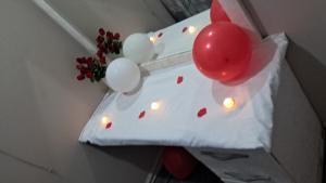 a white pillow with balloons and a vase with flowers at BluSash in Durban