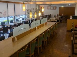 a long table in a restaurant with chairs and tables at APA Hotel Muroran in Muroran