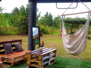 a hammock hanging from a pole with a bench at George - Guest House Shekvetili in K'vemo Natanebi +7 photos
