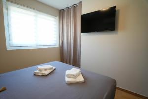 a bedroom with a bed with two towels on it at T2 Les Suites du Roubion in Montélimar