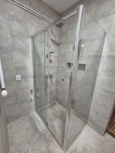 a shower with a glass door in a bathroom at Apartment Laura & Lucija in Osijek