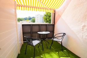 a small balcony with two chairs and a table at T2 Les Suites du Roubion in Montélimar