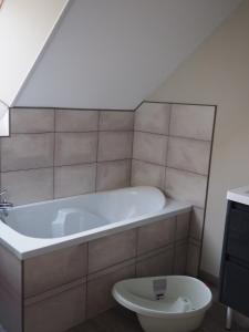 a bathroom with a bath tub and a toilet at Le brin d'air Mayennais in Saint-Julien-du-Terroux +32 photos