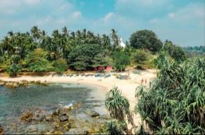 a beach with a group of people laying on the sand at Nisho House Hiriketiya in Hiriketiya