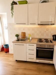 a kitchen with white cabinets and a stove and a sink at Guest House Elizabeta in Split