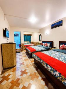 a group of four beds in a room at Hotel Darjeeling palace in Darjeeling