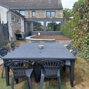 a black table and chairs in front of a house at A l'éc'Art in Wellin