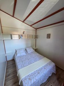 a small bedroom with a bed and a ceiling at Chalet tout confort in Rivières +7 photos