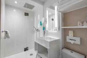 a white bathroom with a sink and a shower at Hotel America in Cannes +47 photos