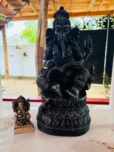 a statue of a deity sitting on a table at Nisho House Hiriketiya in Hiriketiya +28 photos