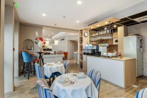 a restaurant with tables and chairs and a bar at Hotel America in Cannes