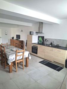 a kitchen with a table and chairs and a kitchen with a sink at Le Galaveyson in Saint-Clair-sur-Galaure